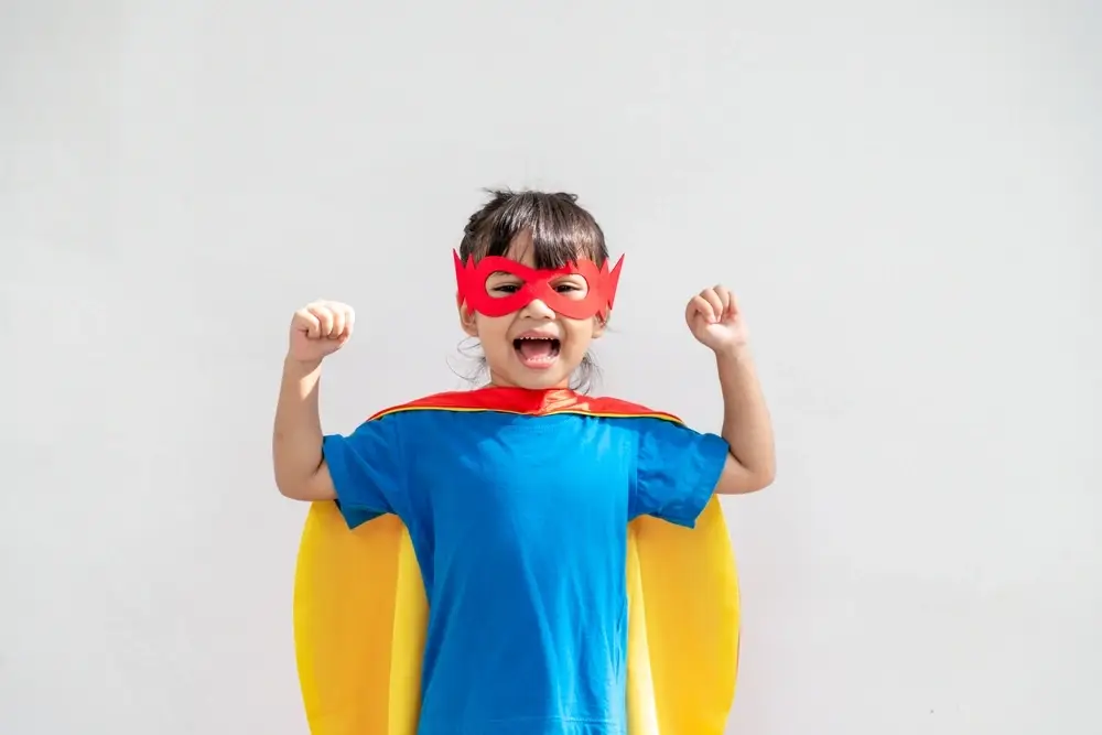 kindercoaching maedchen superheldin gelber umhang jubelt